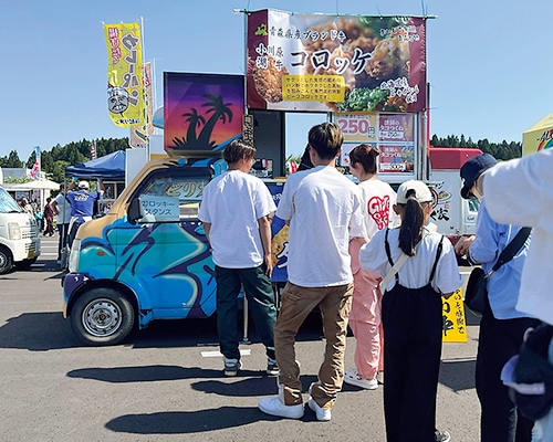 ご当地グルメのキッチンカーに並ぶ人たち