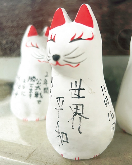 「世界平和」の文字が書かれた狐の人形