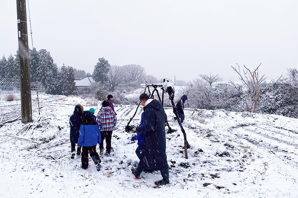 雪のなかを歩く集落の人々