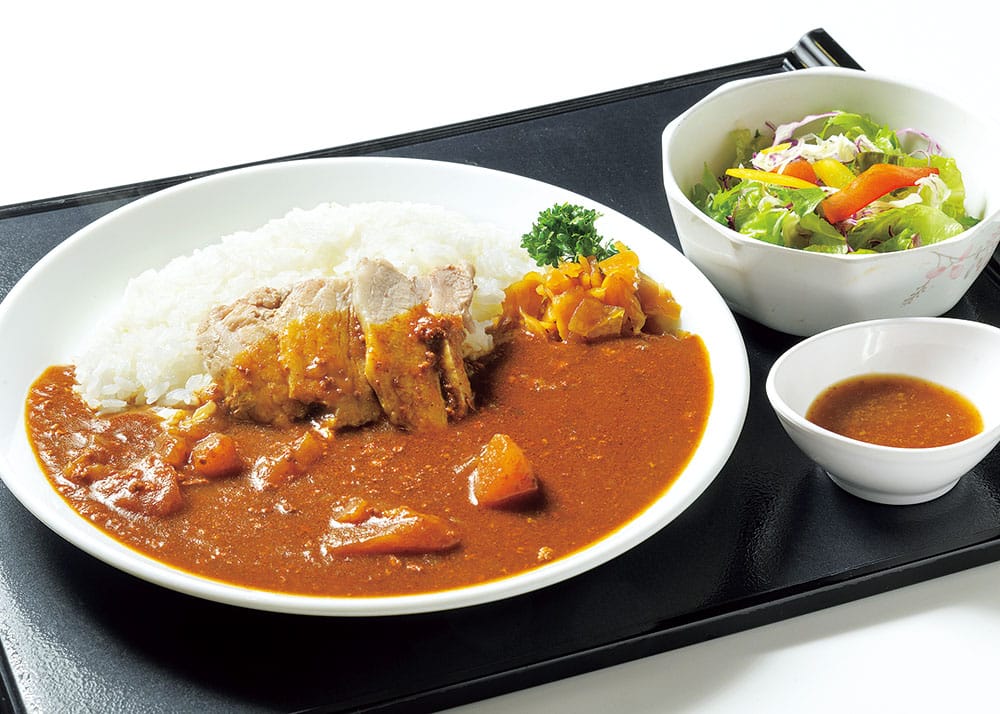 スライスした豚肉が添えられた林檎カレー