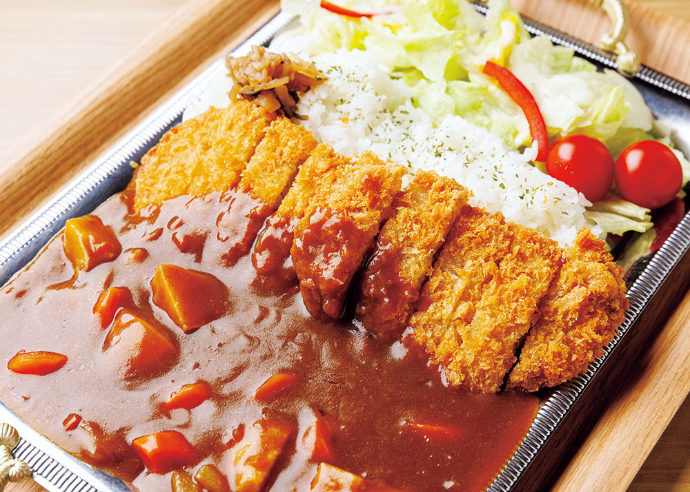 大きな銀色のトレーに盛られたカレー。とんかつ2枚がトッピングされている。